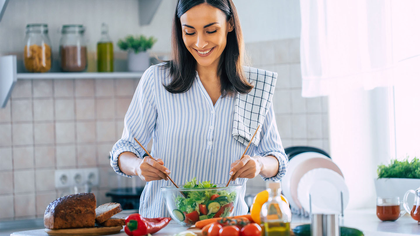 Млада жена приготвя здравословна храна.