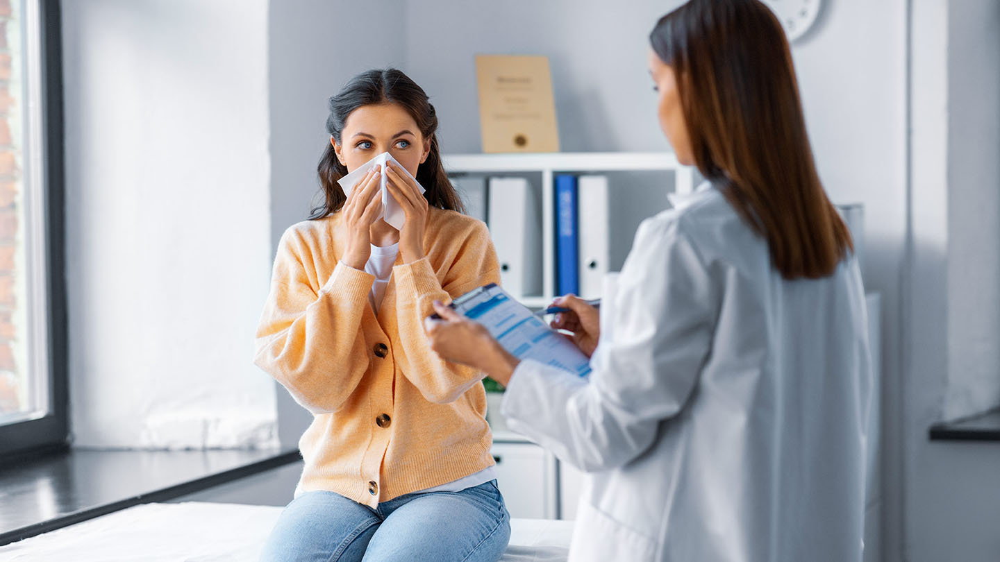 Жена с грип, прегледана от лекар.