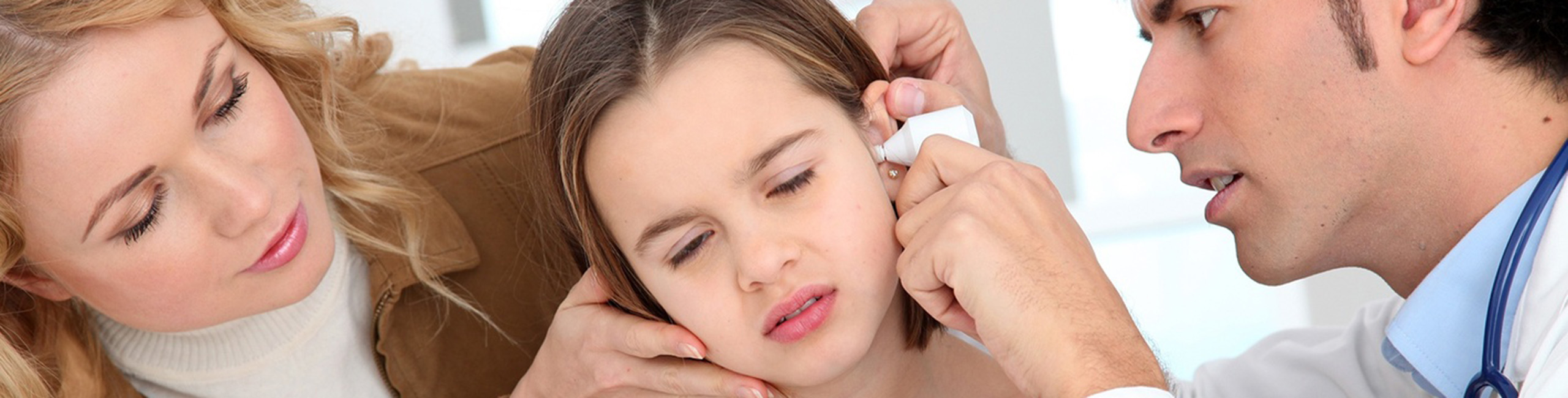 Момиче, преглеждано от лекар за ушна инфекция.