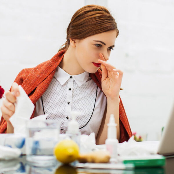 Болна жена с настинка в офиса.