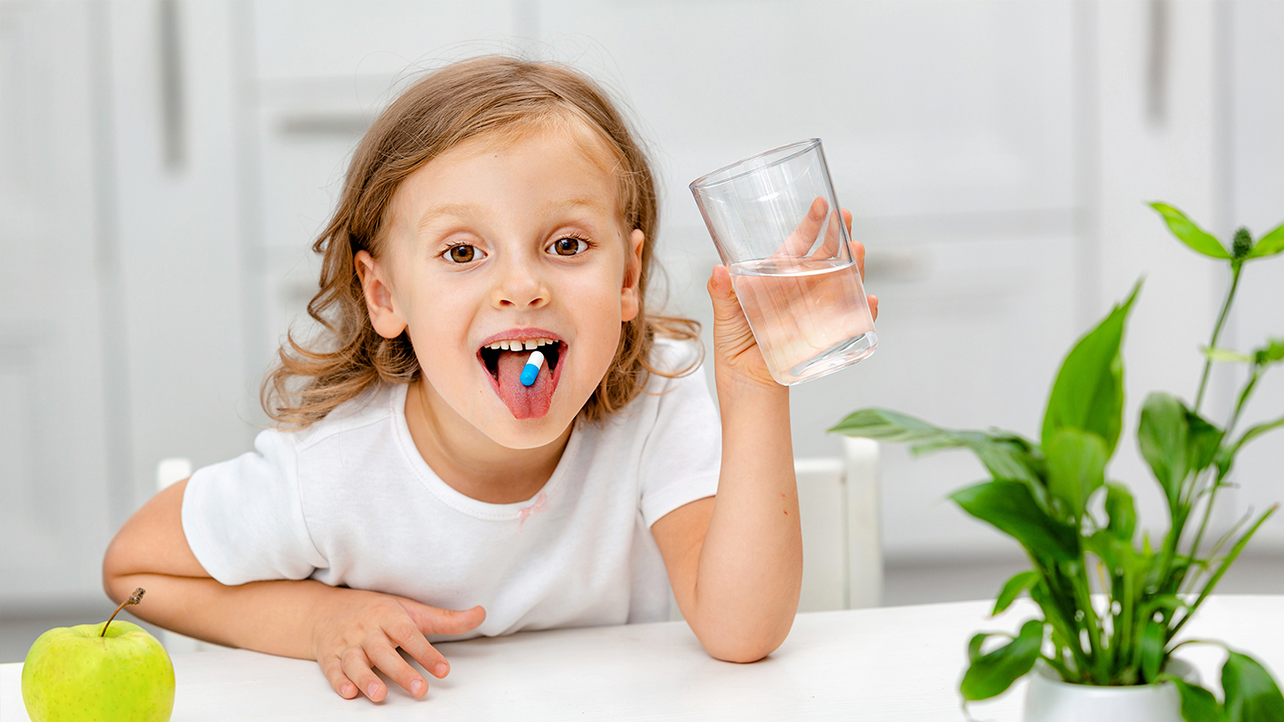 Момичето приема хранителна добавка за имунната си система.