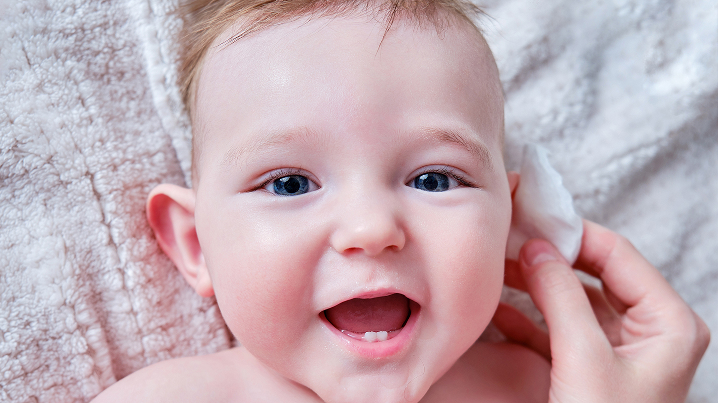 Бебе с ушна инфекция върху одеяло.