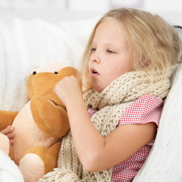 Болно малко момиченце се е вкопчило в плюшена играчка.